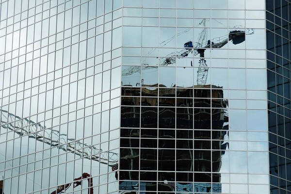 reflection of a crane in a high-rise building