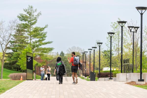 Two students walk down a path on campus
