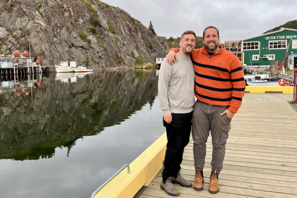 Franco Solimano and Spencer Small standing together in front of water and mountains.