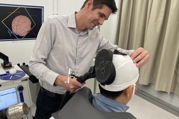 Ben Thompson fitting a device on a patient's head