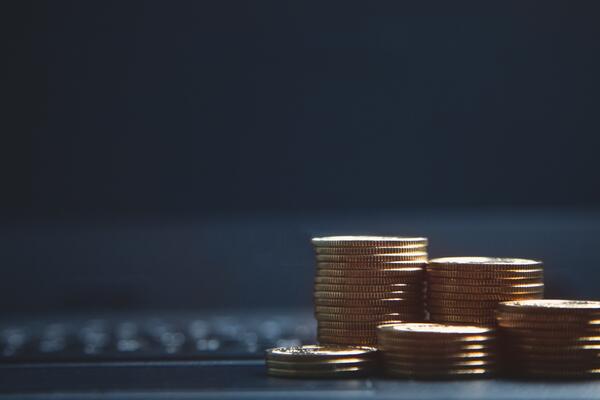 Stacks of coins in front of a computer keyboard
