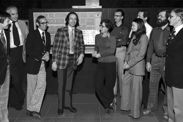 A group of staff pose in front of the IBM computer, circa 1965