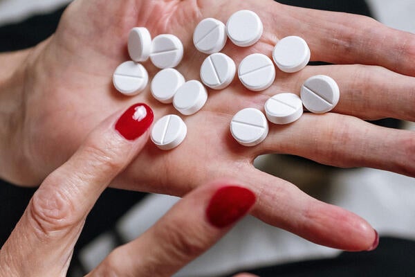 Woman holding white tablets in her hand