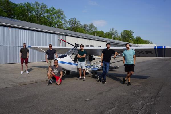 Six members of the Ribbit team standing in front of a plane