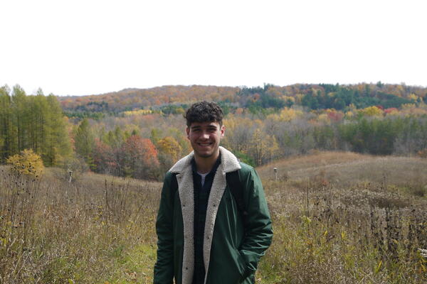 Ethan stands in a meadow in autumn