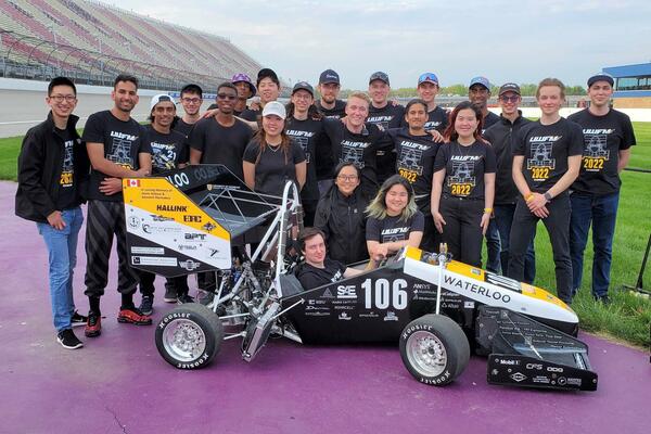 Members of UW Formula Motorsports pose with their car at the Michigan International Speedway.