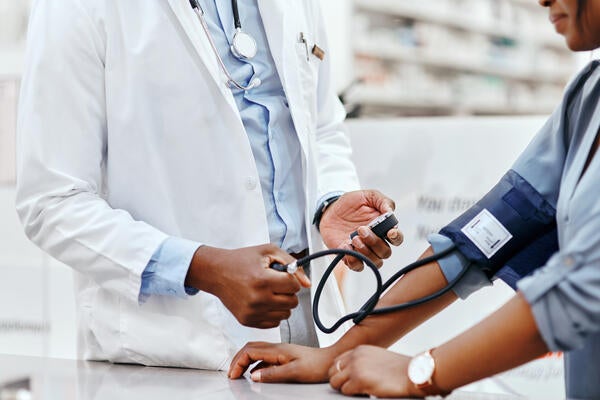 Closeup shot of a pharmacist taking a patient's blood pressure