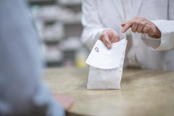 Pharmacist handing prescription to a patient 