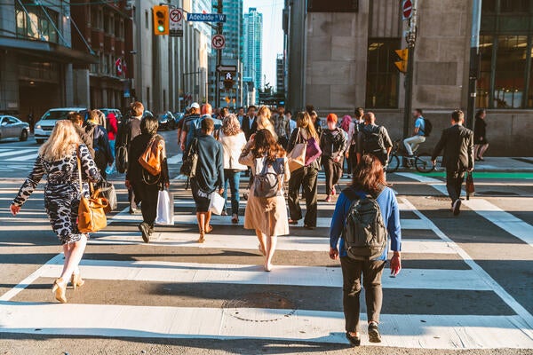 Crowd of unrecognizable people crossing street in Toronto, Canada at rush hour