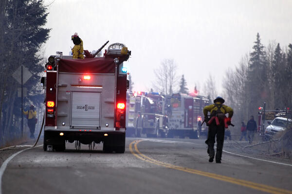 Several firetrucks respond to an active fire scene. 