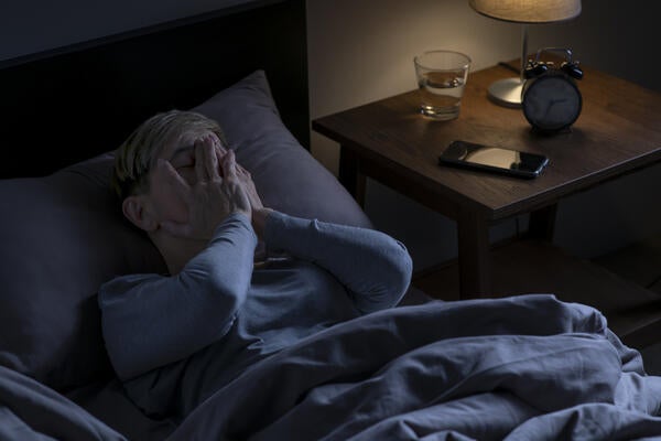 A senior person lying in bed, unable to sleep. (Getty Images/Filmstax) 