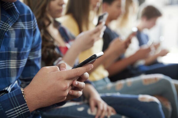 Close up of adolescents using mobile phones 