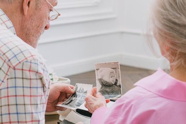 Older adult couple looking at vintage photographs
