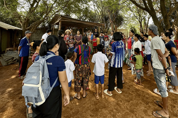 A student wearing a backpack gathers with a community