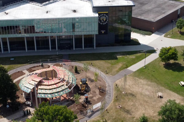 Aerial image of Indigenous gathering space and SLC building with Waterloo Warriors banner on its side.