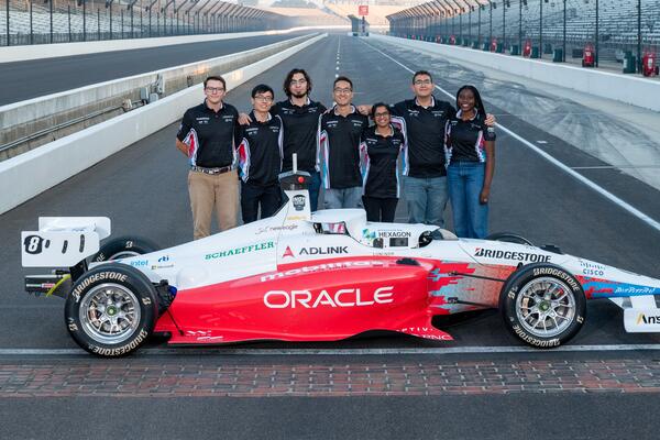 Members of team with their car at Indy Autonomous Challenge.