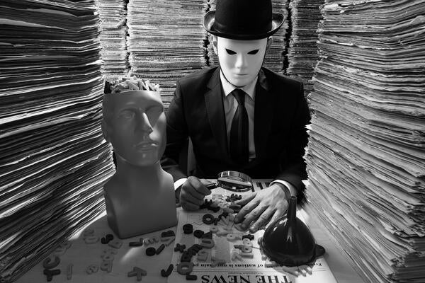 Man in a mask holding a magnifying glass over a newspaper