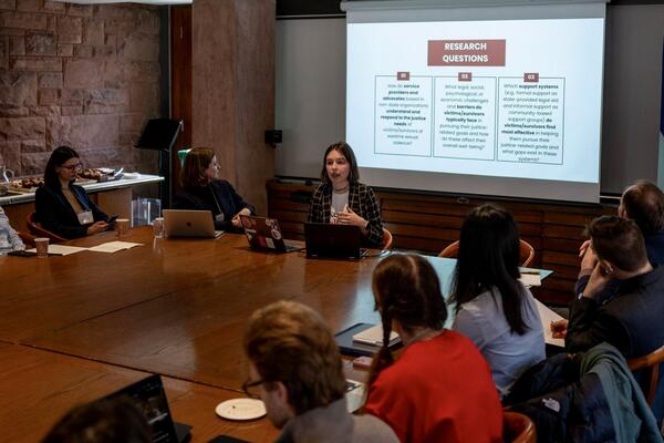 Student presenting to others around boardroom table