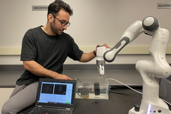 Engineering research associate Moslem Sadeghi Goughari checks his ultrasound robot arm