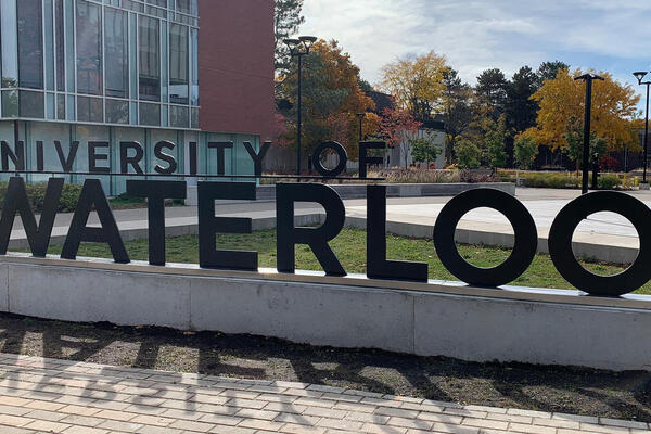 Campus scene with a sign that says University of Waterloo