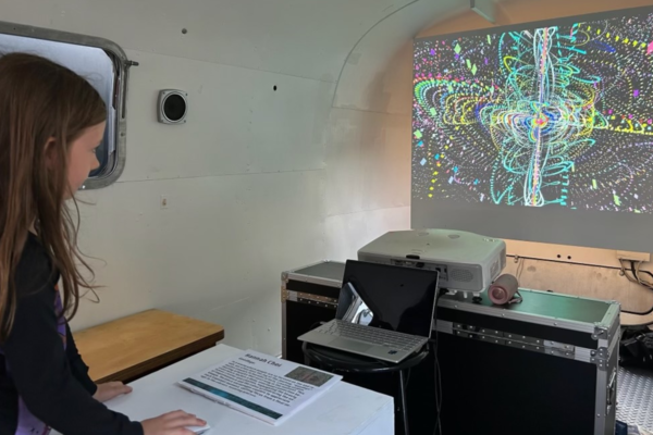 Students in an art bus looking at a abstract designs on a projection screen