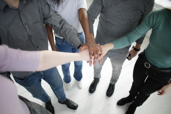 A group of people put their hands together in a circle