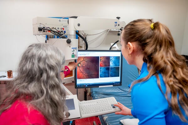 Two scientists study an image of a retina on a computer screen