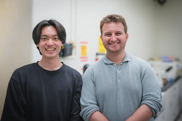 Kevin Shen (left) and Rikard Saqe (right) standing next to each other in a science lab.