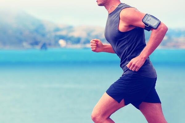 Man running while cell phone is strapped to his arm.