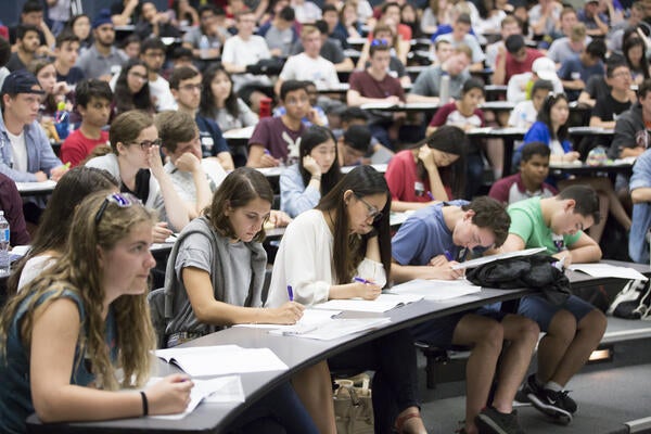 Students taking notes in a lecture hall