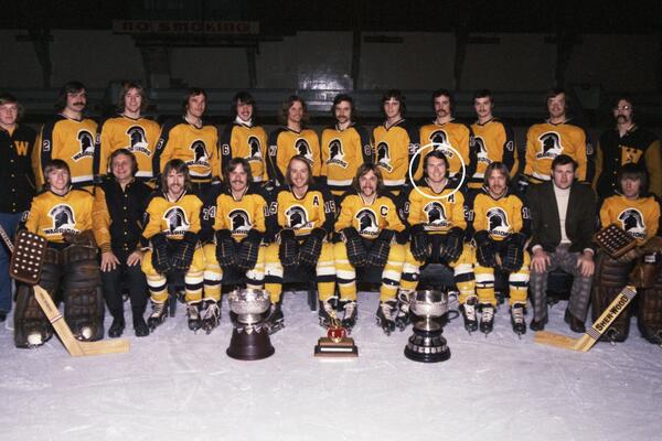 Waterloo Warriors hockey players in uniform pose with three trophies