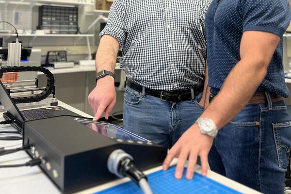 Michael Lavdas (right), CTO of Tenomix, and engineer Jacob Tryon working with the benchtop device's display screen.