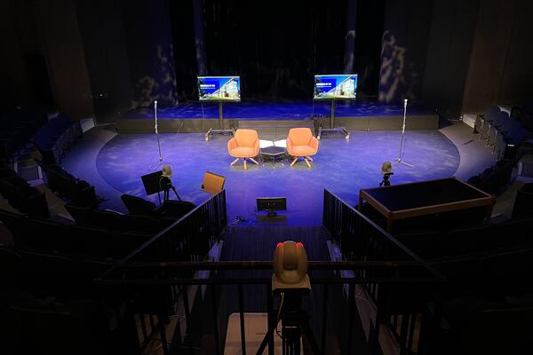 President's Forum stage set-up with new two empty chairs and two monitors behind them at the Theatre of the Arts