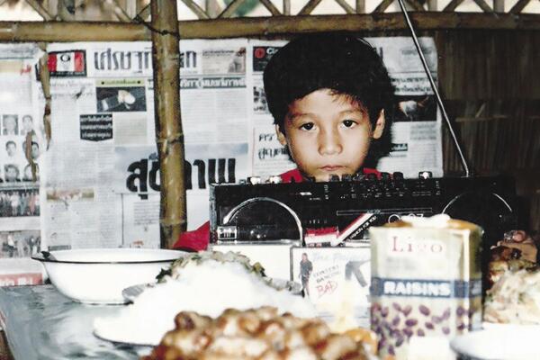 Archival photo of a young Vin Nguyen at his birthday part in a tent in a refugee camp