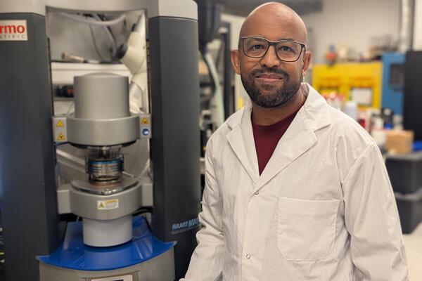 Waterloo researcher Dr. Tizazu Mekonnen stands next to a rheometer, which is used to test the flow properties of hydrogels.