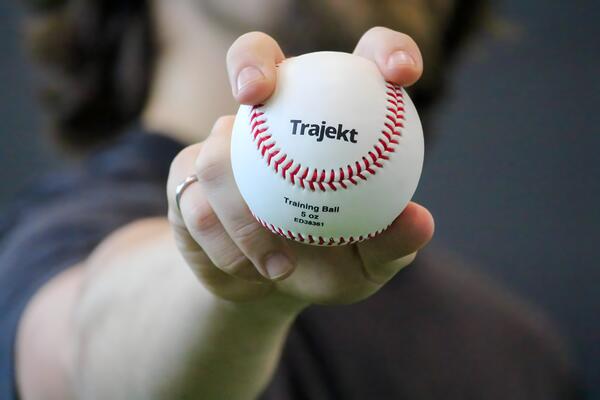 Person holds out a baseball with a fastball grip