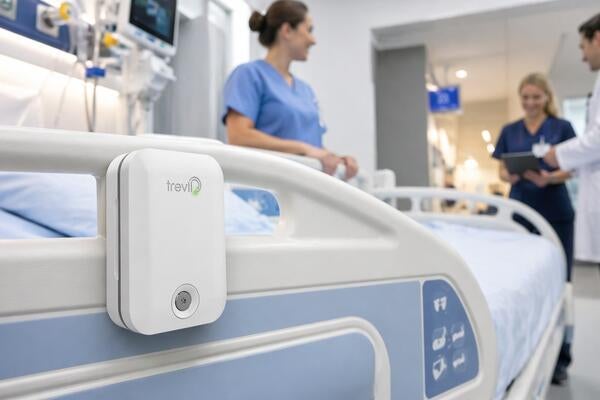 Trevii unit is attached to the side of a hospital bed with medical staff in the background