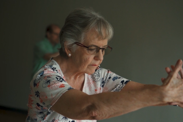 An elderly woman does stretching exercises