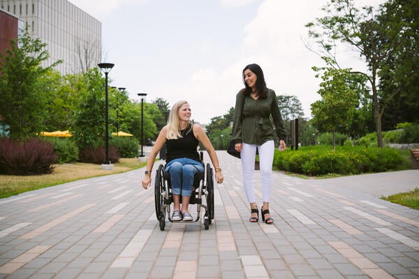Woman wheelchair user and able-bodied friend on Waterloo campus