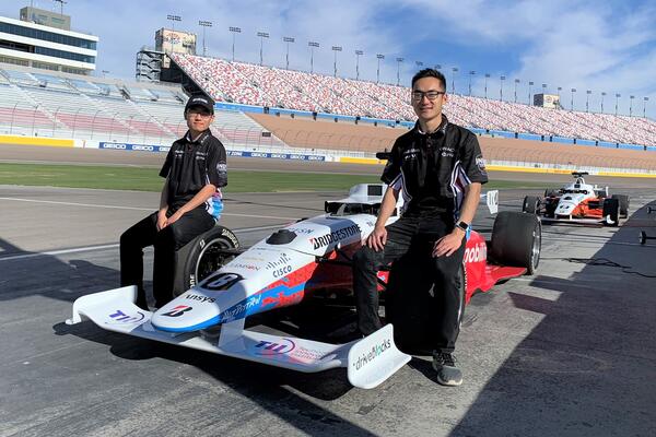 Behn Zhang (left) and Brian Mao with their autonomous racecar at the Las Vegas Motor Speedway.