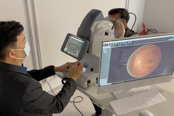 An ophthalmologist imaging the back of a patient's eye