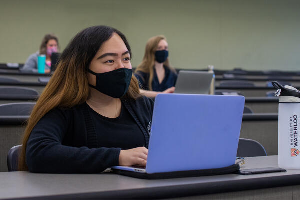 Student sitting at desk with mask