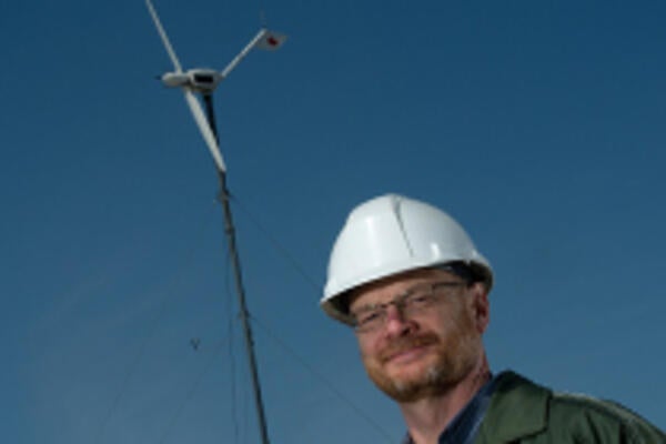 David Johnson standing in front of wind turbine