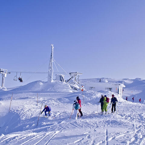 skiiers on top of a snowy hill