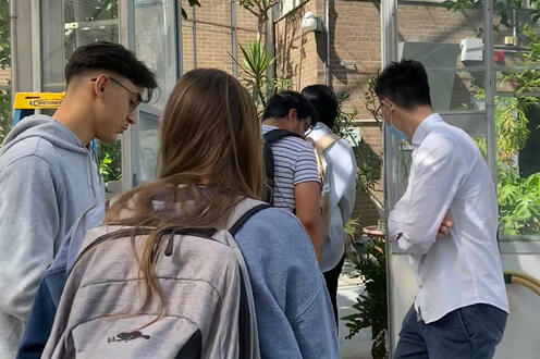 Participants in the Real Research program are seen walking through the green house on campus