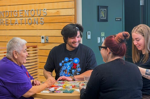 In the Visiting Aunties Program, Rhea Green connects with students and staff while they create their own beadwork 