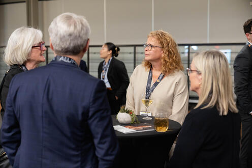 Four people standing around a table. 