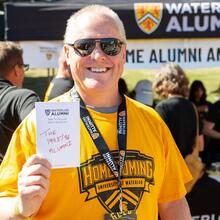 Alum holds up a card saying what he loves about Waterloo
