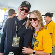 A couple smiles in the Alumni VIP Tent