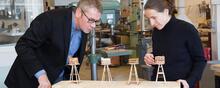 Two-architects-looking-at-four-small-wood-models 